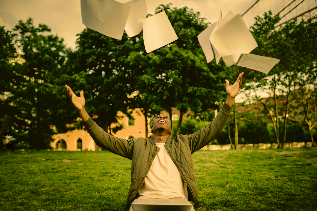 person happily throwing paper in the air