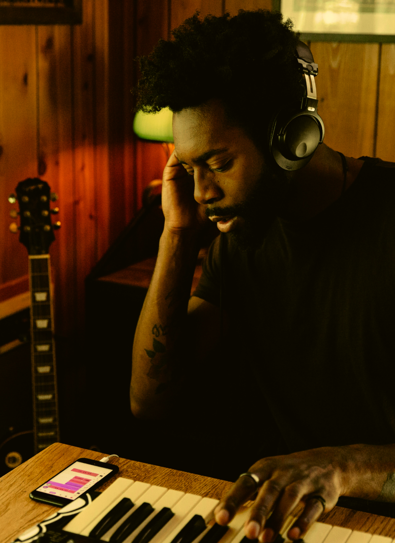 person with headphones and piano